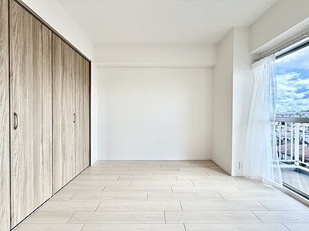 木製収納付きの明るい洋室、バルコニーに面しています
