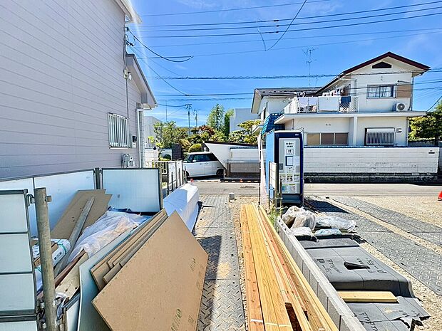 住宅街の道路沿いにある駐車スペースと周辺の建物