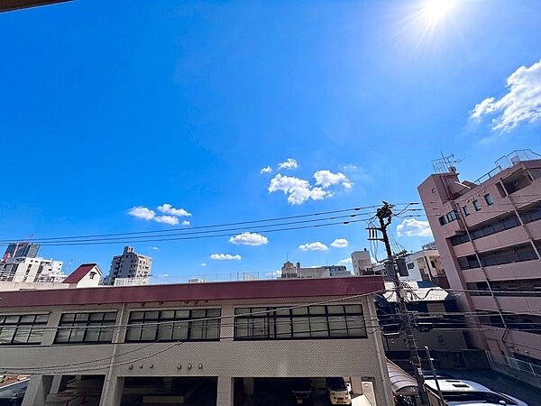 青空が広がる建物の外観と周辺の住宅環境