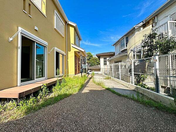 住宅外観と庭先、道路の様子が見える写真です