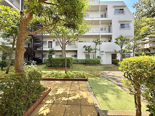 緑に囲まれたマンションの外観と共用庭