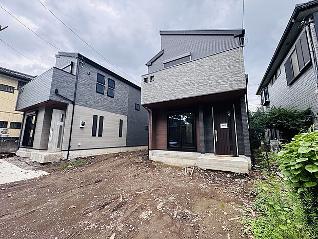 周囲に住宅がある、建設中の二階建て住宅の外観です