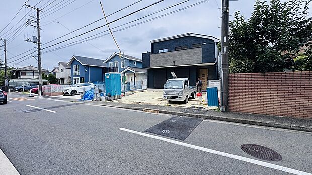 戸建て住宅と駐車スペースが見える道路沿いの様子