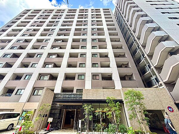 中高層マンションの外観エントランス周囲は植栽で整えられている