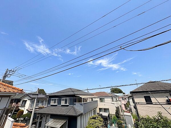 晴天の空の下、住宅街の外観と周辺の景観が見える