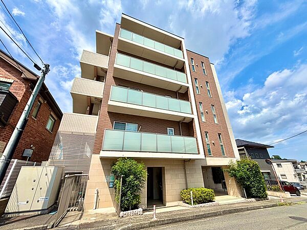 近隣住宅が並ぶ中にある5階建てマンションの外観です