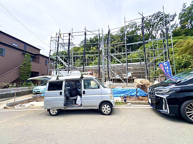 建築中の住宅現場と隣の車両が映る外観