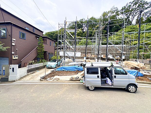 住宅の建設現場と車がある駐車スペースの外観