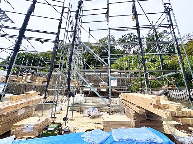 建設中の木造住宅現場と周囲の緑豊かな環境
