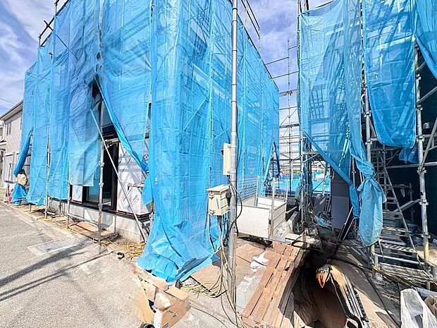 建築中の現場で、ブルーシートや足場が設置されています