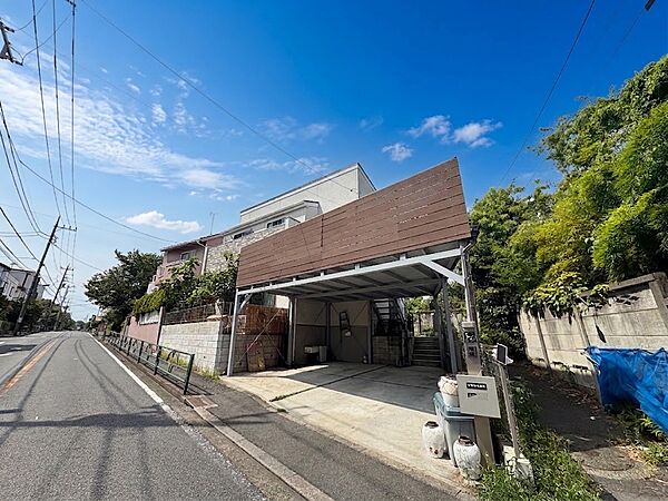 住宅街にある屋根付きの駐車スペース付き住宅の外観です