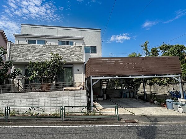 植栽のある住宅とカーポート付き駐車スペース