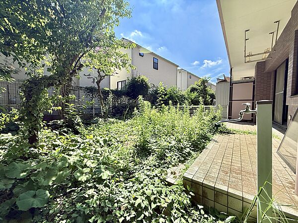 庭に面した緑豊かなテラスと建物外観の一部が見える