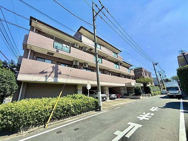 周辺道路と植栽のあるマンション外観