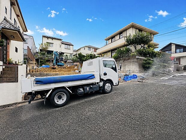 住宅街の舗装道路に停車したトラックと周囲の住宅環境