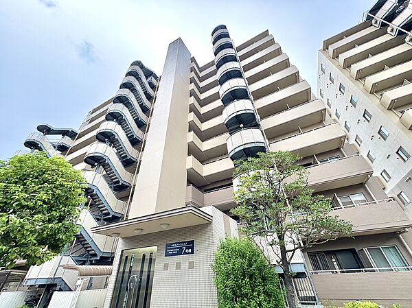 高層マンションの外観周囲に緑が見える環境