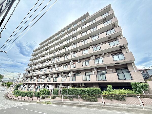 複数階建てのマンション外観周辺に電柱と道路が見える