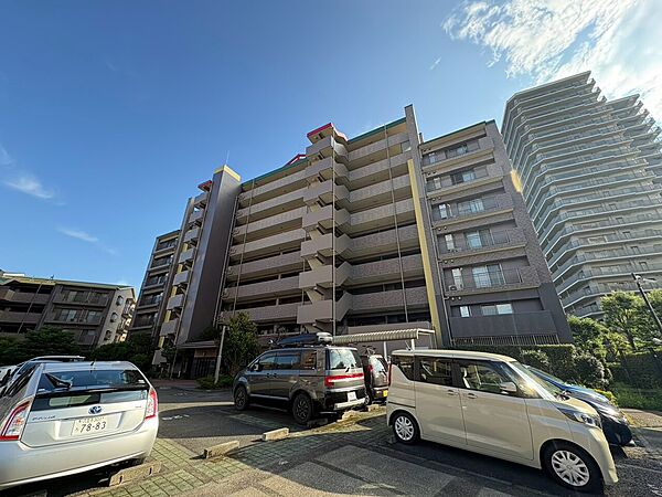 複数階建てのマンション外観と駐車場の様子