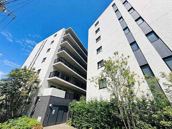 緑の植栽に囲まれた高層マンションの外観