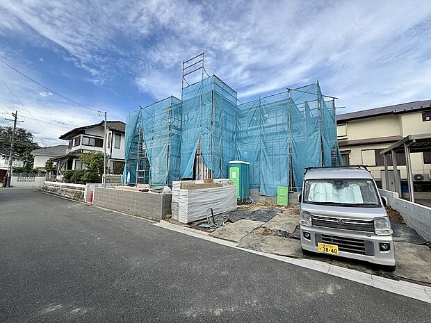 建築中の建物と前面道路、周辺住宅の様子