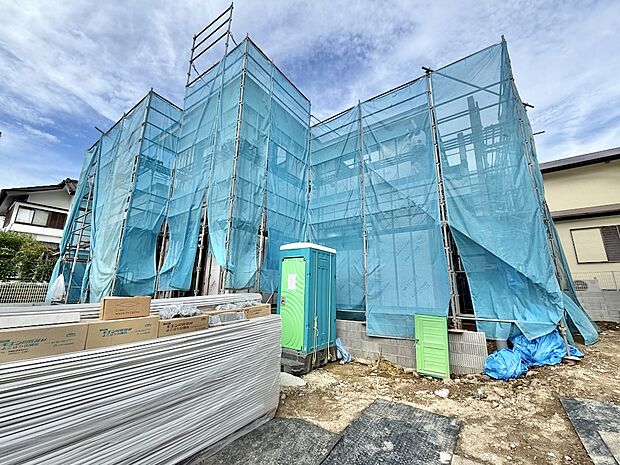 青い養生シートで覆われた建築中の建物