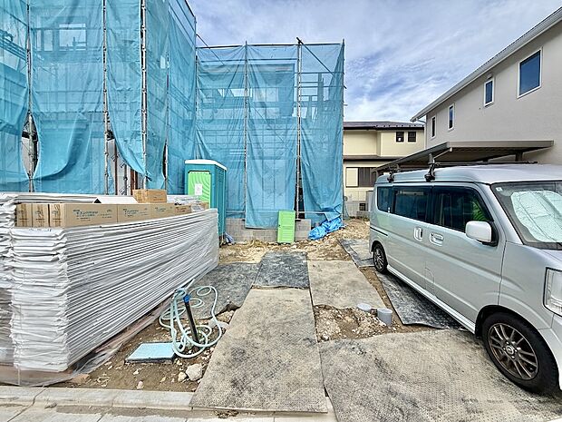 建築中の建物と資材、敷地内の駐車車両