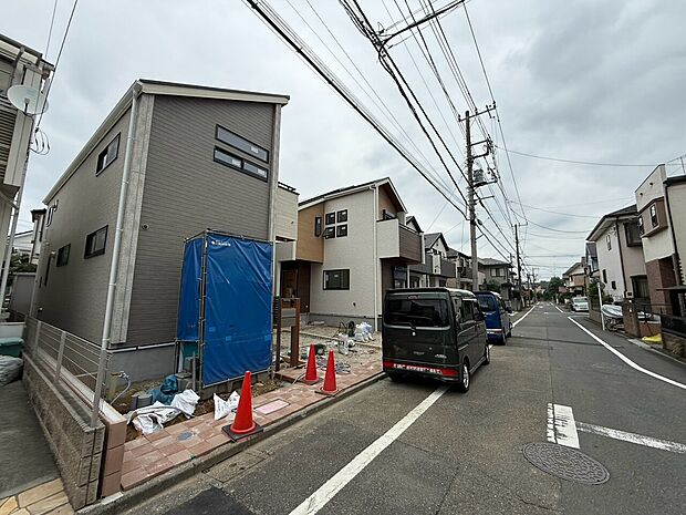 住宅地の新築工事現場と舗装された道路の様子