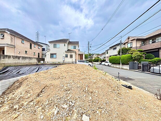 住宅地の整地済みの土地周囲に住宅が並ぶ静かな環境