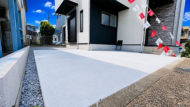 シンプルなコンクリートの駐車スペースと住宅外観