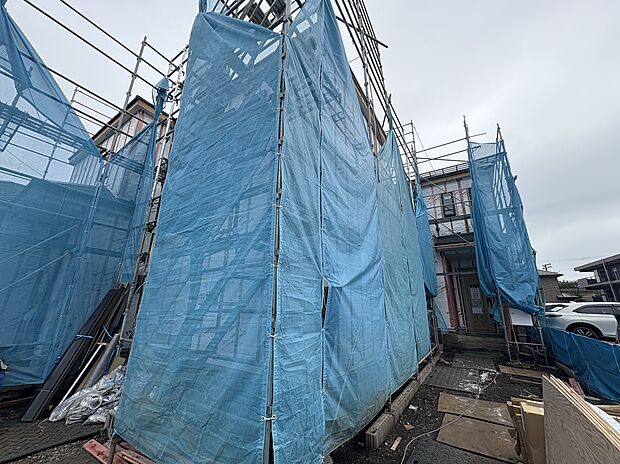 青い養生シートで覆われた建築中の建物