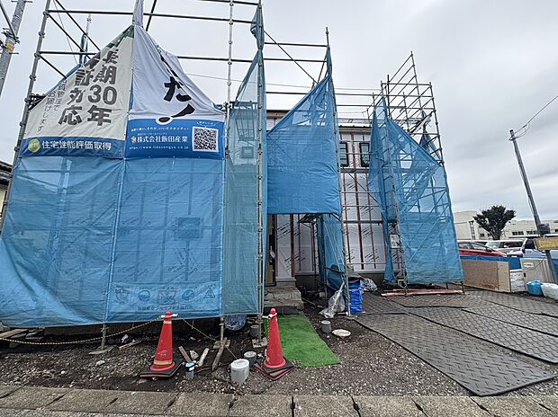 青い養生シートで囲われた建築中の建物