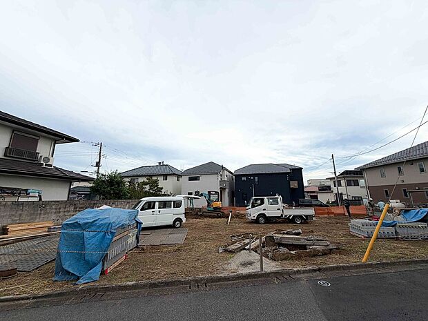 建築工事中の住宅用地と近隣の住宅風景