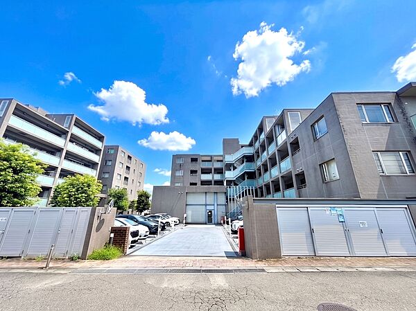 青空の下にある住宅街の集合住宅の外観です