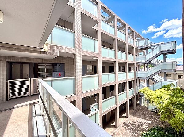 複数階のバルコニーと外階段が見える集合住宅の外観です