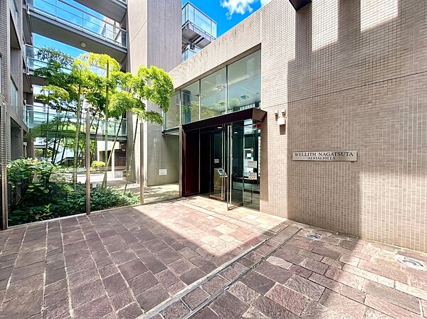 植栽のある建物入口の明るい外観です