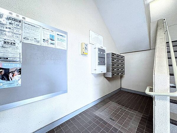 掲示板と階段があるマンションの共用エントランス