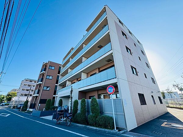 周囲に住宅がある4階建てのマンション外観です