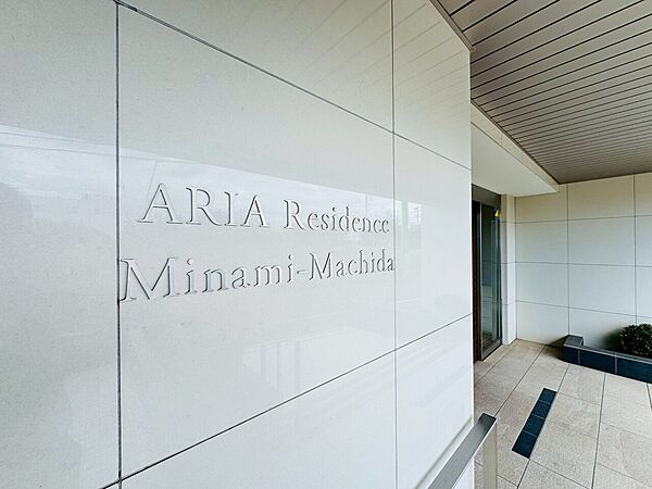建物名が記された外壁のシンプルなエントランス付近