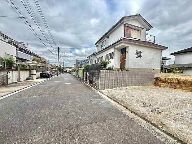 住宅街の角地にある2階建ての住宅と周辺道路の様子です