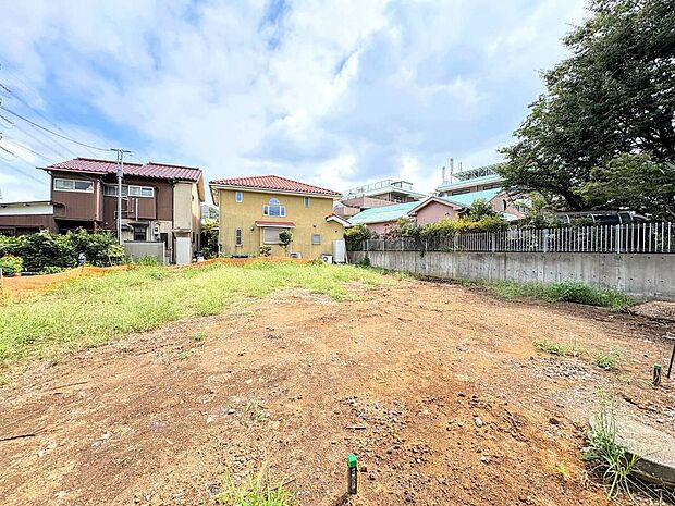 住宅地の空き地で周囲に建物がある敷地の様子