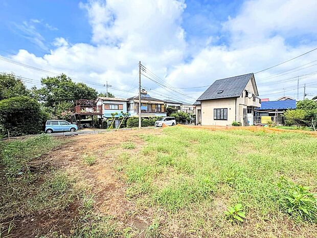 住宅地の広い更地、周囲に一戸建てがあります