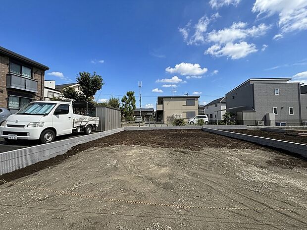 住宅街にある整地済みの土地と駐車スペースの様子