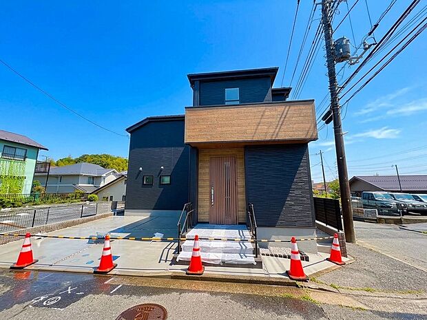 新築の黒い外壁の住宅、玄関前にスロープと階段あり