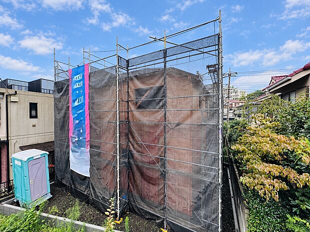 建築中の建物を覆う足場と養生シート