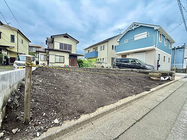 道路に面した住宅の外観と整地された敷地