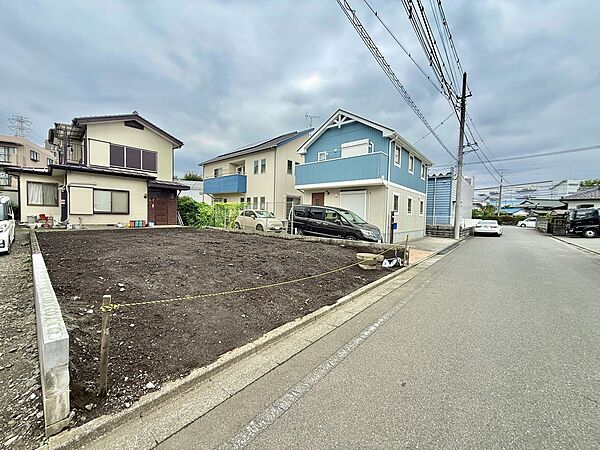 前面道路と隣接する更地、住宅街の街並み