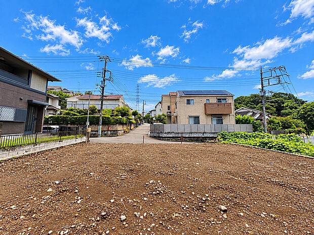 整地された広い土地周囲に住宅や緑が見える