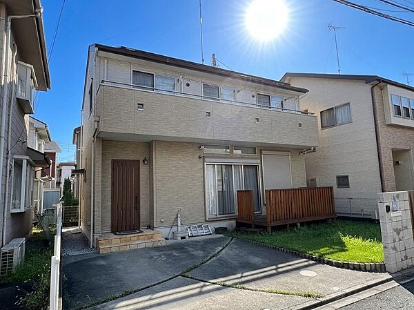 白い外壁の2階建て住宅と駐車スペース