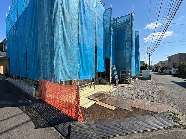 青いシートで覆われた建物と前面道路