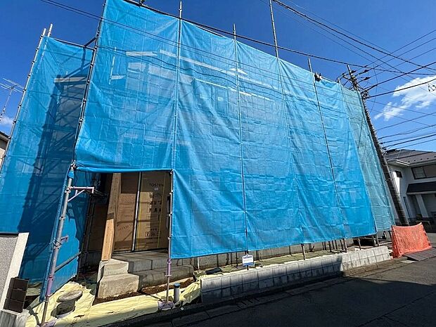 青い養生シートで覆われた建築中の建物
